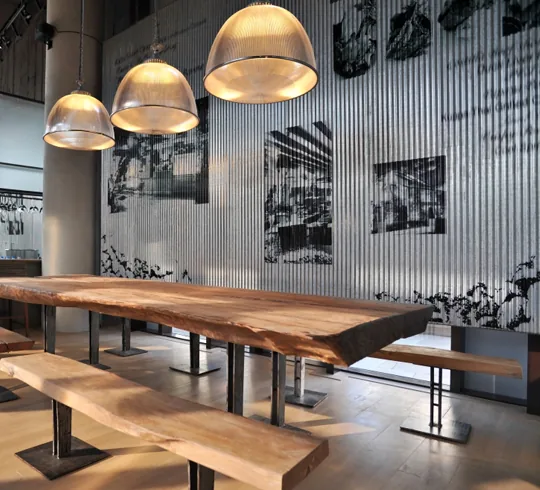 Restaurant dining interior with fluted wall panels and pendant lighting